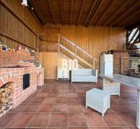 Zaujímavý rodinný dom s veľkým pozemkom, krásnou záhradou a bohatým pr - Exteriér rodinného domu v Lietave s tehlovým grilom a terasovým posedením.