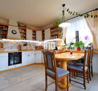 Zaujímavý rodinný dom s veľkým pozemkom, krásnou záhradou a bohatým pr - Kuchyňa v rodinnom dome s dreveným dekorom, množstvo rastlín a svetelných zdrojov.