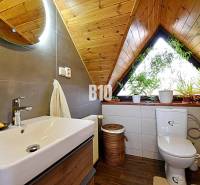 Zaujímavý rodinný dom s veľkým pozemkom, krásnou záhradou a bohatým pr - Kúpeľňa v rodinnom dome s dreveným dekorom a rastlinami na parapete.