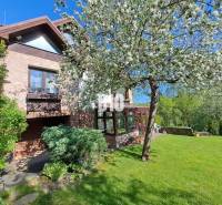 Zaujímavý rodinný dom s veľkým pozemkom, krásnou záhradou a bohatým pr - Rodinný dom v Lietave obklopený záhradou s kvitnúcimi stromami a trávnikom.