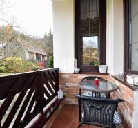 Zaujímavý rodinný dom s veľkým pozemkom, krásnou záhradou a bohatým pr - Balkón rodinného domu v Lietave s tehlovým obkladom a výhľadom na záhradu.