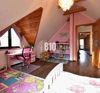 Zaujímavý rodinný dom s veľkým pozemkom, krásnou záhradou a bohatým pr - Detská izba v rodinnom dome s ružovým nábytkom a podlahou s dreveným dekorom.
