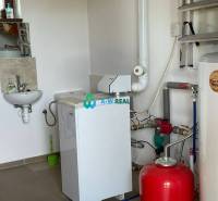 Apartmánový dom na predaj blízko termálneho kúpaliska - Pohľad na technickú miestnosť s umývadlom a kotlom, vhodnú pre obchodné priestory.
