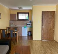 Apartmánový dom na predaj blízko termálneho kúpaliska - Kuchynka a jedálenský kút v byte so štyrmi stoličkami, svetložlté steny.