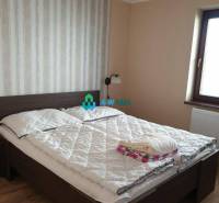 Apartmánový dom na predaj blízko termálneho kúpaliska - Spálňa s posteľou, pruhovanou tapetou, s výhľadom na ulici neuvedené v obchodné priestory.