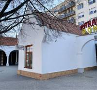 DUNASJKÁ STREDA – OBCHODNÝ PRIESTOR PRIAMO V CENTRE MESTA - Budova s oblúkmi a nápisom na Námestí Ármina Vámbéryho v Dunajskej Strede.