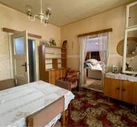 VRAKÚŇ – STARÝ RODINNÝ DOM NA PREDAJ S VEĽKÝM POZEMKOM - 24 ÁROV - Tradičná jedáleň v rodinnom dome s čipkovaným obrusom a dreveným nábytkom.