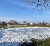VRAKÚŇ –VEĽKÝ STAVEBNÝ POZEMOK (24 ÁROV) SO STARÝM RODINNÝM DOMOM NA P - Zasnežená krajina vo Vrakúni s rodinnými domami v pozadí a modrou oblohou.