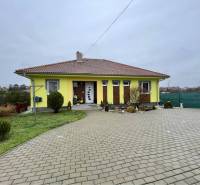 VKUSNÝ 4-IZBOVÝ RODINNÝ DOM S GARÁŽOU NA PREDAJ V OBCI TOPOĽNÍKY - Rodinný dom v Topoľníkoch má žltú fasádu, škridlovú strechu, upravenú záhradu a dlažbu.