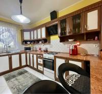 VKUSNÝ 4-IZBOVÝ RODINNÝ DOM S GARÁŽOU NA PREDAJ V OBCI TOPOĽNÍKY - Kuchyňa v rodinnom dome so žltými stenami, dreveným dekorom a bielymi skrinkami.