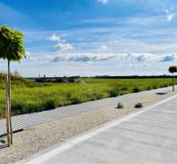 DUNAJSKÁ STREDA – SLNEČNÉ STAVEBNÉ POZEMKY NA PREDAJ V PROJEKTE VINICA - Krajinom okolo Dunajskej Stredy sa tiahne pozemok na bývanie s chodníkom a stromami.