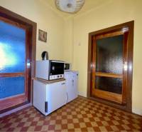 TOPOĽNÍKY – 4-IZBOVÝ RODINNÝ DOM NA PREDAJ NA 14 ÁROVOM POZEMKU - Kuchynka v rodinnom dome s dlažbou so vzorom a drevenými dverami.