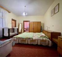 TOPOĽNÍKY – 4-IZBOVÝ RODINNÝ DOM NA PREDAJ NA 14 ÁROVOM POZEMKU - Spálňa v rodinnom dome s posteľou, detskou postieľkou, skrinkami a zrkadlom.