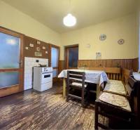 TOPOĽNÍKY – 4-IZBOVÝ RODINNÝ DOM NA PREDAJ NA 14 ÁROVOM POZEMKU - Kuchyňa v rodinnom dome s podlahou s dreveným dekorom, jedálenským stolom a sporákom.