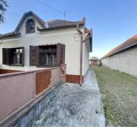 TOPOĽNÍKY – 4-IZBOVÝ RODINNÝ DOM NA PREDAJ NA 14 ÁROVOM POZEMKU - Rodinný dom na Hlavnej ulici v Topoľníkoch s drevenými okenicami a terasou.