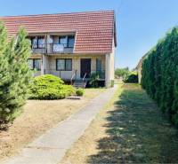 A-W REAL | POSCHODOVÝ DVOJDOM S GARÁŽOU NA PREDAJ V OBCI BÚČ - Rodinný dom na Hlavnej ulici v Búči s červenou strechou a zeleným záhradným plotom.