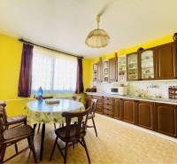 A-W REAL | POSCHODOVÝ DVOJDOM S GARÁŽOU NA PREDAJ V OBCI BÚČ - Kuchyňa v rodinnom dome s drevenými skrinkami, žltými stenami a podlahou s dreveným dekorom.