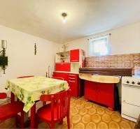 A-W REAL | POSCHODOVÝ DVOJDOM S GARÁŽOU NA PREDAJ V OBCI BÚČ - Kuchyňa v rodinnom dome so svetlými stenami, červeným nábytkom a vzorovanou podlahou.