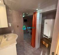 Znížená cena!  Rodinný dom s vnútorným aj vonkajším bazénom na krásne  - Kúpeľňa s umývadlom, kotlom a oranžovým závesom vytvára funkčný priestor v rodinnom dome.