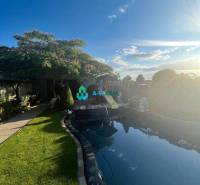 Znížená cena!  Rodinný dom s vnútorným aj vonkajším bazénom na krásne  - Rodinný dom s krásnou záhradou, bazénom a modrou oblohou na ulici neuvedene.