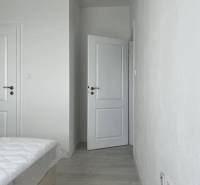 Luxusný byt na prenájom úplne nový kompletne zariadený s garážou. - Na ulici Panonsky haj, 3-izbový byt: biela spálňa, otvorené dvere, svetlá podlaha.
