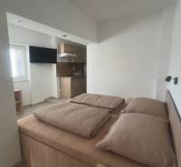 Apartmány na prenájom. - Svetlá izba s posteľou, kuchynkou a televízorom; pohodlný relax v súkromí.