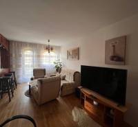 Rodinný  dom na predaj v Gabčíkove - Obývacia izba s drevenou podlahou, sedačkou, televízorom a ozdobným osvetlením v rodinnom dome.