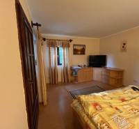 Rodinný  dom na predaj v Gabčíkove - Útulná spálňa s dreveným nábytkom, balkónom a televízorom v rodinnom dome.