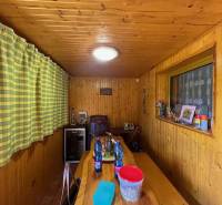 Rodinný  dom na predaj v Gabčíkove - Drevený rodinný dom s dlhou lavicou a teplými záclonami, vybavený doplnkami na stole.