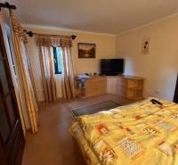 Rodinný  dom na predaj v Gabčíkove - Spálňa s posteľou, skriňami a televízorom, útulný priestor v rodinnom dome.