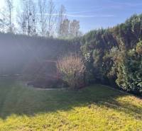 Rodinný  dom na predaj v Gabčíkove - Záhrada s trávnikom a kríkmi, tienistý kút a rodinný dom v pozadí.