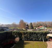 Rodinný  dom na predaj v Gabčíkove - Záhrada v Gabčíkove s výhľadom na okolité rodinné domy a modrú oblohu.