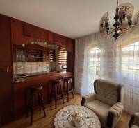 Rodinný  dom na predaj v Gabčíkove - Obývačka rodinného domu s dreveným barom a pohodlnými kreslami, presvetlené záclonami.