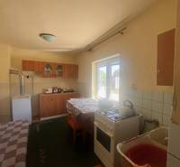 ☎️    0918 846 340    Rodinný dom okamžite obývateľný. - Kuchyňa v rodinnom dome s plynovým sporákom, chladničkou a jedálenským stolom.