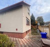 ☎️ 0918 846 340       Výrazne znížená cena len 210 000 eu. Dvojgenerač - Rodinný dom v Dunajskej Strede s omietkou, tehlovým soklom, vegetáciou a odpadovými nádobami.