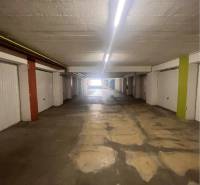 Garáž na prenájom. - Interiér garáží s osvetlením a betónovou podlahou.