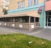 Znížená cena!!!!   Obchodný priestor na predaj. - Exteriér obchodných priestorov v Dunajskej Strede, s reštauračnou terasou a zelenou trávou.