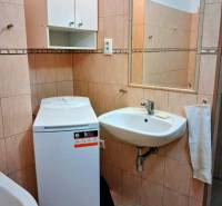 ☎️   0918 846 340           Byt v centre mesta na Jesenského ulici. - Kúpeľňa v 1-izbovom byte s práčkou, umývadlom a nástennou skrinkou.