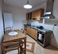 ☎️   0918 846 340           Byt v centre mesta na Jesenského ulici. - Kuchyňa v 1-izbovom byte s dreveným nábytkom, sporákom a podlahou so vzorom.