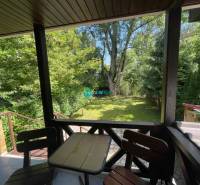 Odstúpenie nájomnej zmluvy - rekreačná chata v obci Bodíky!!! Cena  84 - Na obrázku je terasa, ktorá ponúka pohľad na zelenú záhradu.