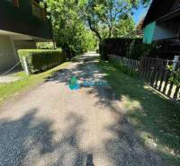 Odstúpenie nájomnej zmluvy - rekreačná chata v obci Bodíky!!! Cena  84 - Stromová ulica s chatami a zelenými plotmi, slnečný deň na ulici Bodíky.