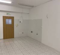 Skvelá ponuka!!! Prenájom nebytového priestoru na podnikateľské účely  - Interiér budovy s keramickou dlažbou, drevenými dverami a svetlými stenami.