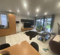 Na predaj: 3-izbový rodinný dom na predaj v obci Lesné Kračany - Obývacia izba v rodinnom dome s podlahou s dreveným dekorom, pohovkou a televízorom.