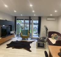 Na predaj: 3-izbový rodinný dom na predaj v obci Lesné Kračany - Obývacia izba s televízorom, pohovkou a podlahou s dreveným dekorom v rodinnom dome.