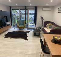 Na predaj: 3-izbový rodinný dom na predaj v obci Lesné Kračany - Obývacia izba v rodinnom dome s podlahou s dreveným dekorom a veľkorysým sedením.