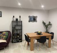 Na predaj: 3-izbový rodinný dom na predaj v obci Lesné Kračany - Obývacia izba v rodinnom dome s podlahou s dreveným dekorom, stolom, pohovkou a rastlinou.