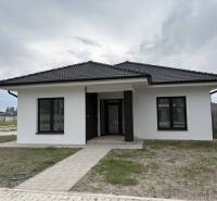 ☎️0917656551 - Rodinný dom na ulici FLORIDA VILLA PARK v Dunajskej Strede s tmavou strechou a trávnikom.