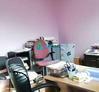 Kancelársky priestor s klimatizáciou na prenájom - Kancelária s ružovými stenami, stoličkami a stolom, na ulici neuvedené.