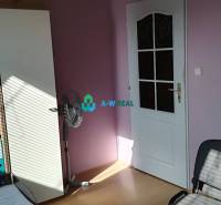 Kancelársky priestor s klimatizáciou na prenájom - Kancelárie s fialovými stenami, stolným ventilátorom a časťou kancelárskeho nábytku na ulici.