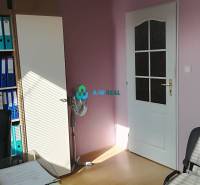 Kancelársky priestor s klimatizáciou na prenájom - Na obrázku sú kancelárie so stoličkami, ventilátorom a farebnými šanónmi v regáloch.